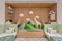 a child's bedroom with a giraffe on the wall